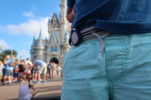 closeup of jiobit clipped to waistband with cinderella castle in background