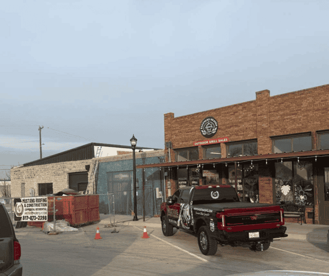 Mustang Roofing truck parked outside a local restaurant after storm damage repair.