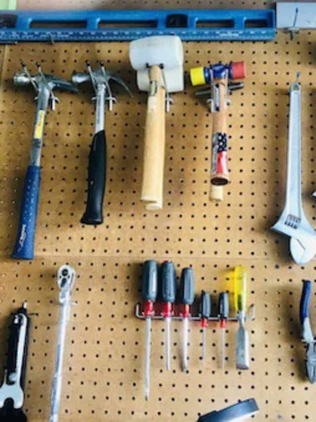 Pegboard wall holding a collection of hammers, wrenches and screwdrivers