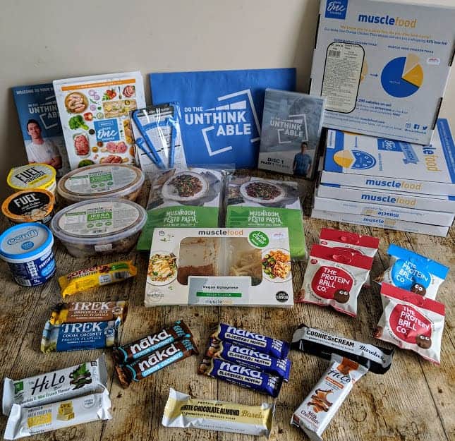 wooden table full of meals, snacks and porridge pots for the do the unthinkable plan from musclefood