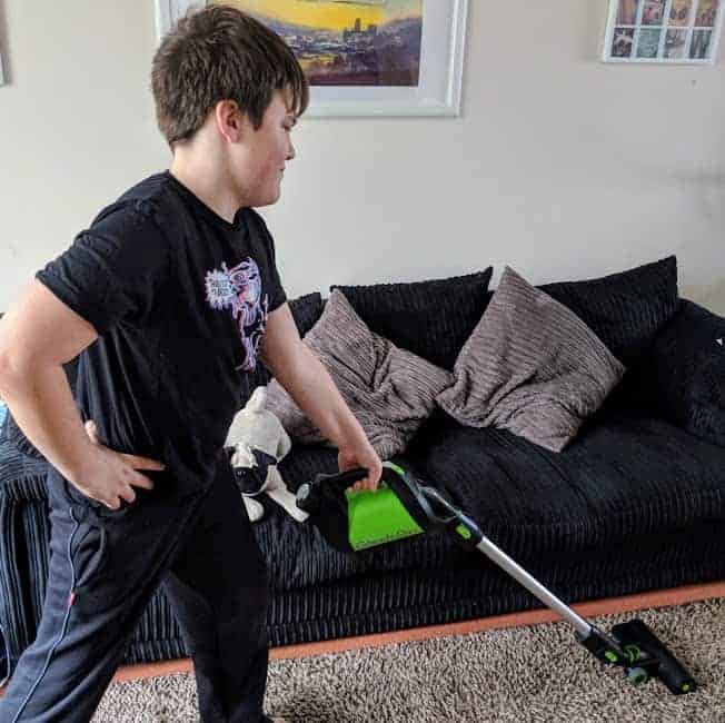 Young boy hoovering a carpet