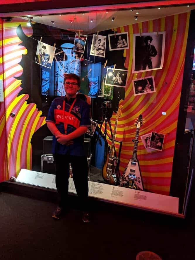 Teenage boy standing in front of a wall at the British Music Experience in Liverpool