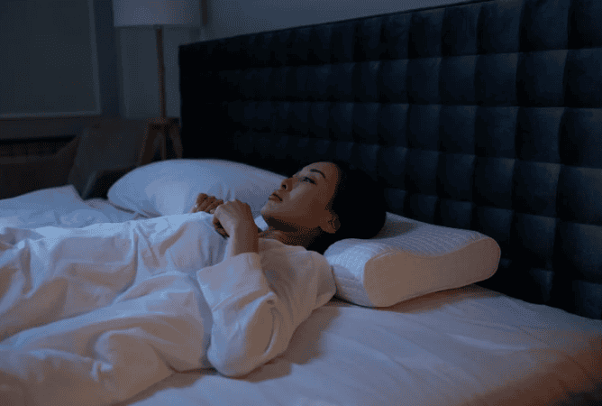 mulher acesa na cama com inônia