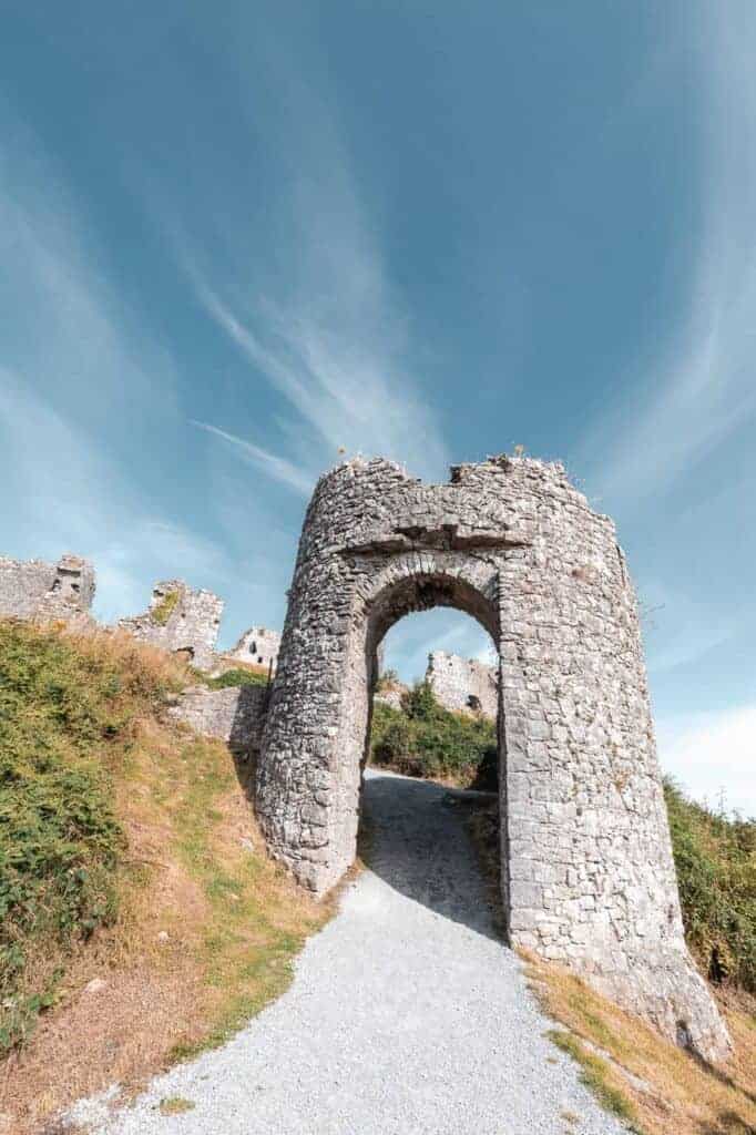 An angled shot of the stone gate at the Rock of Dunamase, highlighting its archway and the surrounding greenery.