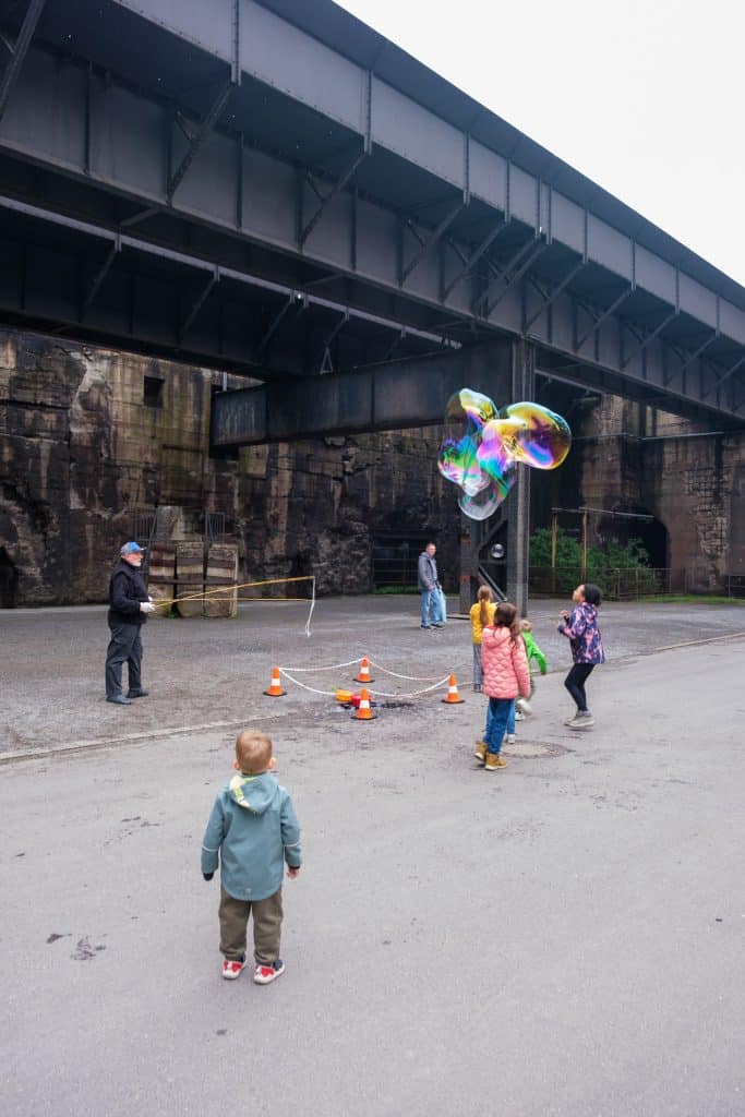 Kinder jagen Seifenblasen am Hochofen 5 im Landschaftspark Duisburg-Nord