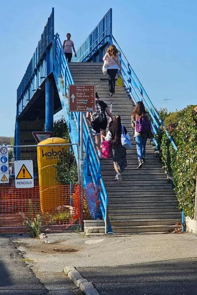 Blue pedestrian bridge near Ostia Antica train station, used by visitors to cross safely to the archaeological site and medieval village.