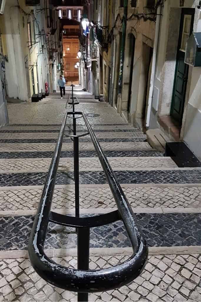 A quiet, charming street in Lisbon with traditional cobblestones, a highlight of exploring Lisbon on foot.