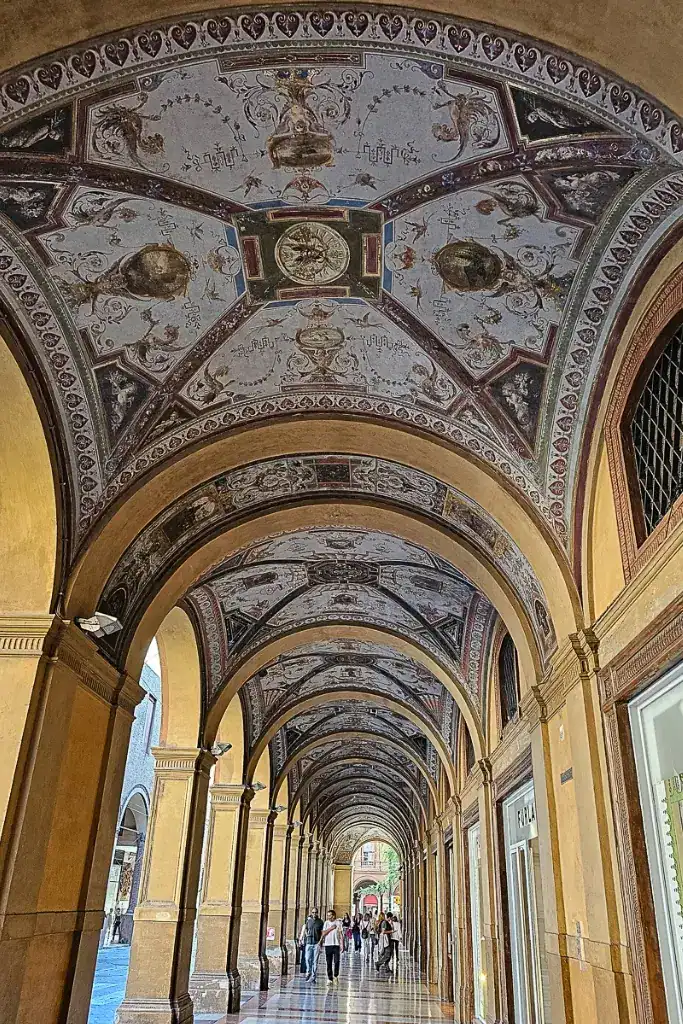 Ornate ceiling of the UNESCO-listed porticoes of Bologna along Via Farini — a scenic walk from Bologna Centrale to the city center.