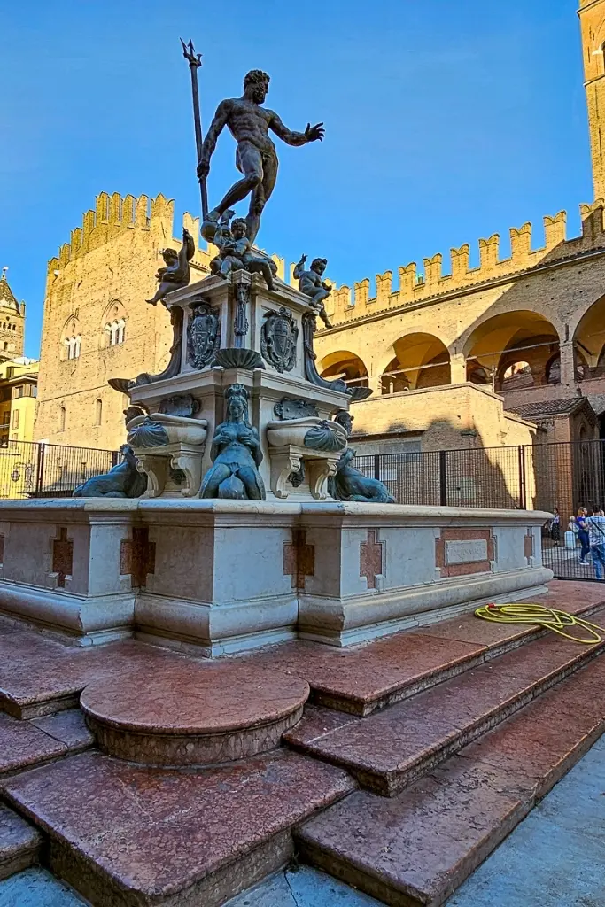 Statue of Neptune surrounded by sea nymphs at the Fontana del Nettuno in Piazza del Nettuno, one of Bologna’s most famous landmarks and a must-photograph Renaissance monument in the city center.