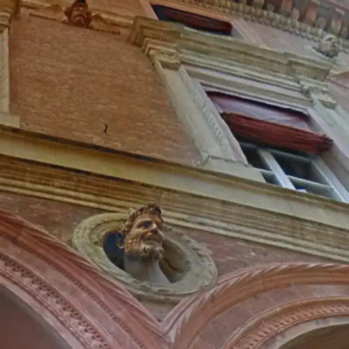 A hidden devil’s head sculpture on a Bologna façade, whose spooky gaze from a window niche sparks one of the city’s weirdest myths.