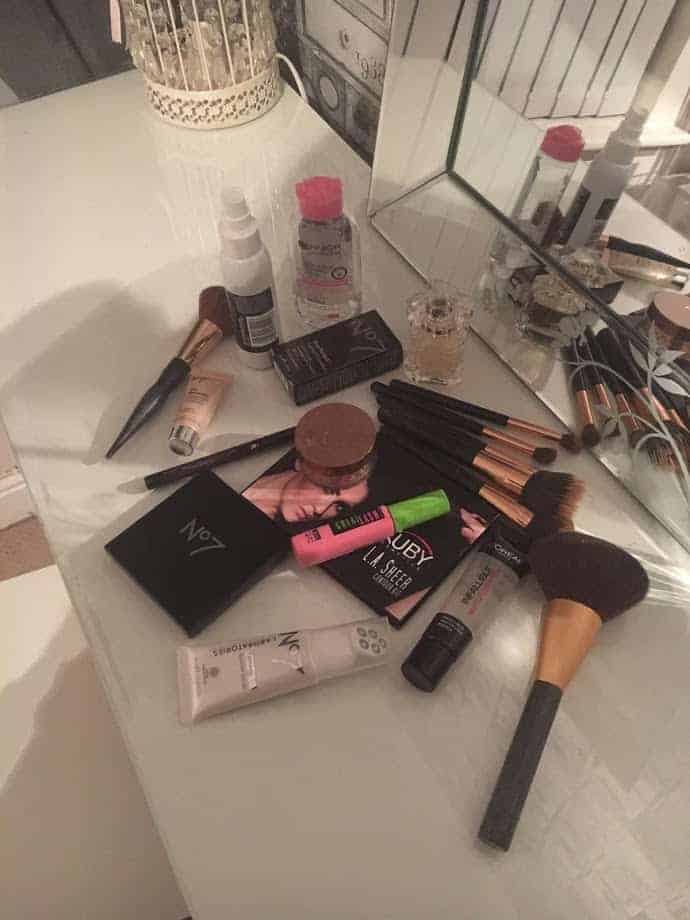 A selection of makeup items and brushes on dressing table