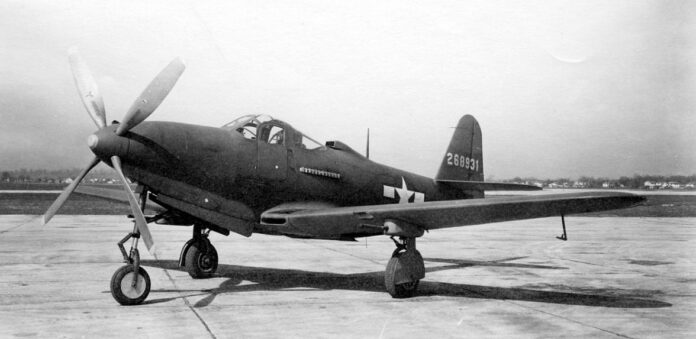 Bell P-63 Kingcobra jachtvliegtuig op de vluchtlijn, klaar voor inspectie of onderhoud, met zichtbare cockpit en propeller.