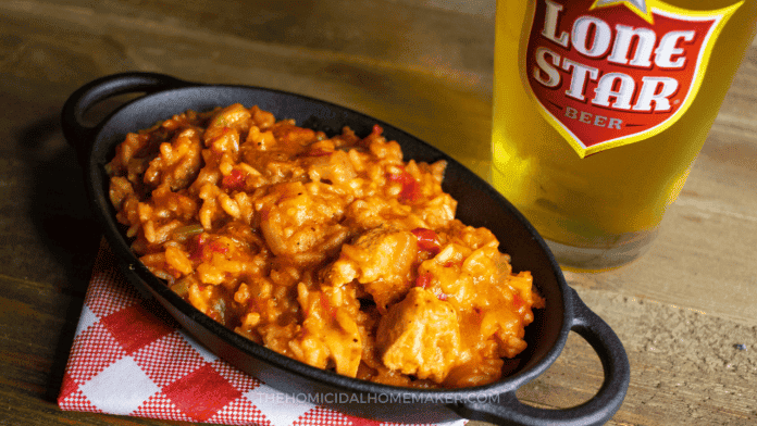 Cast iron dish full of spicy rice jambalaya on a checkered napkin, on a wooden tabletop
