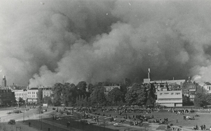 Mensen verzamelen zich tijdens het bombardement op Rotterdam, mei 1940. Rechts is het Sonneveld Huis zichtbaar.