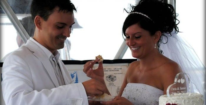 Bride and groom enjoying the cake on a Sandlapper Tours boat. Wedding dinner cruise Charleston SC
