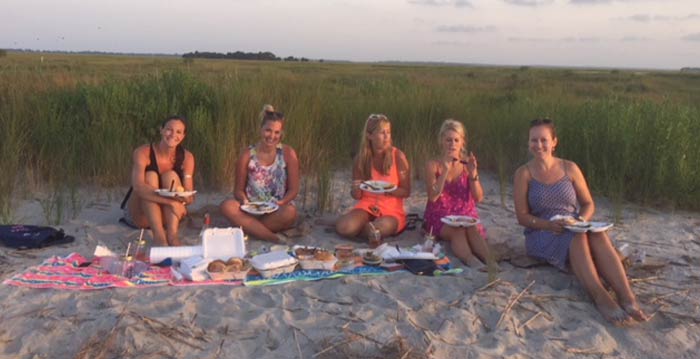 Group of women enjoying a picnic on the beach. Boat charter Charleston SC