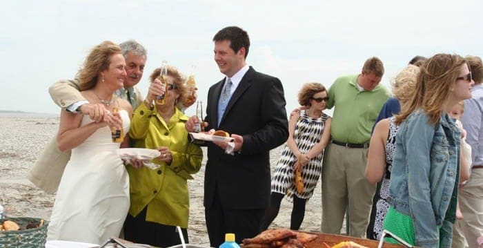 Wedding party enjoying their beers and food on the beach. Wedding dinner cruise Charleston SC