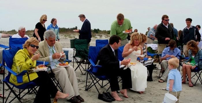 Wedding party enjoying their dinner on the beach. Wedding dinner cruise Charleston SC