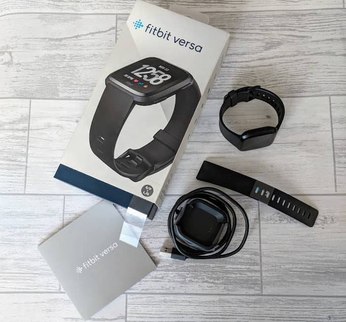 Fitbit Versa box and straps on wooden surface