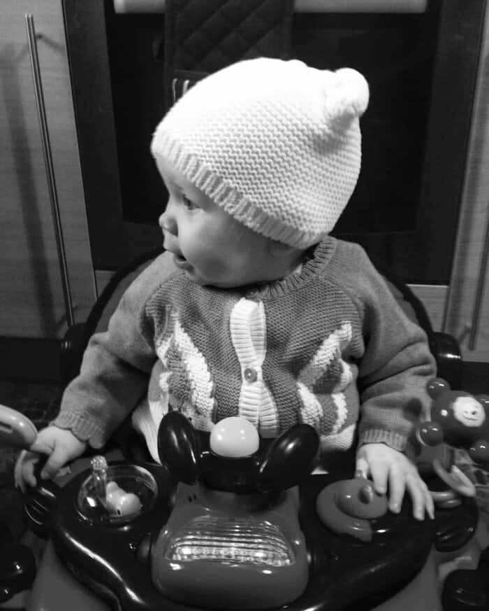 Baby girl all ready to go out with her woolly hat and cardi on