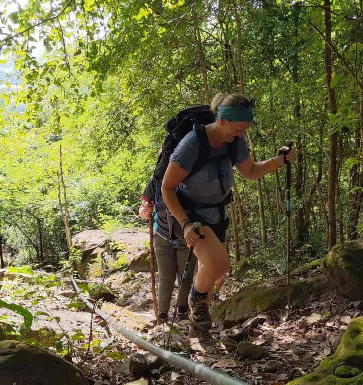 Trekkers exploring hidden Angkor temples on foot near Angkor Wat, walking through jungle trails, ancient ruins, and secluded archaeological sites.