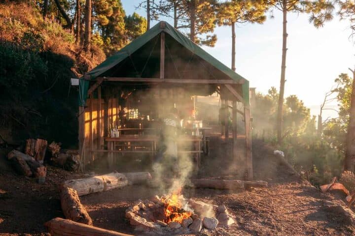 Fire pit and covered dining area at OX Expeditions campsite on Acatenango during golden hour