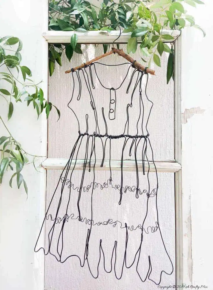 Add little elegance and whimsy to your wall art with this DIY wire dress tutorial. Made from jewelry wire, it's rustic and fun to do. Includes dress template and instructions for printing. Can be hung indoors or out. #WireArt #DIYTutorial #WallDecor