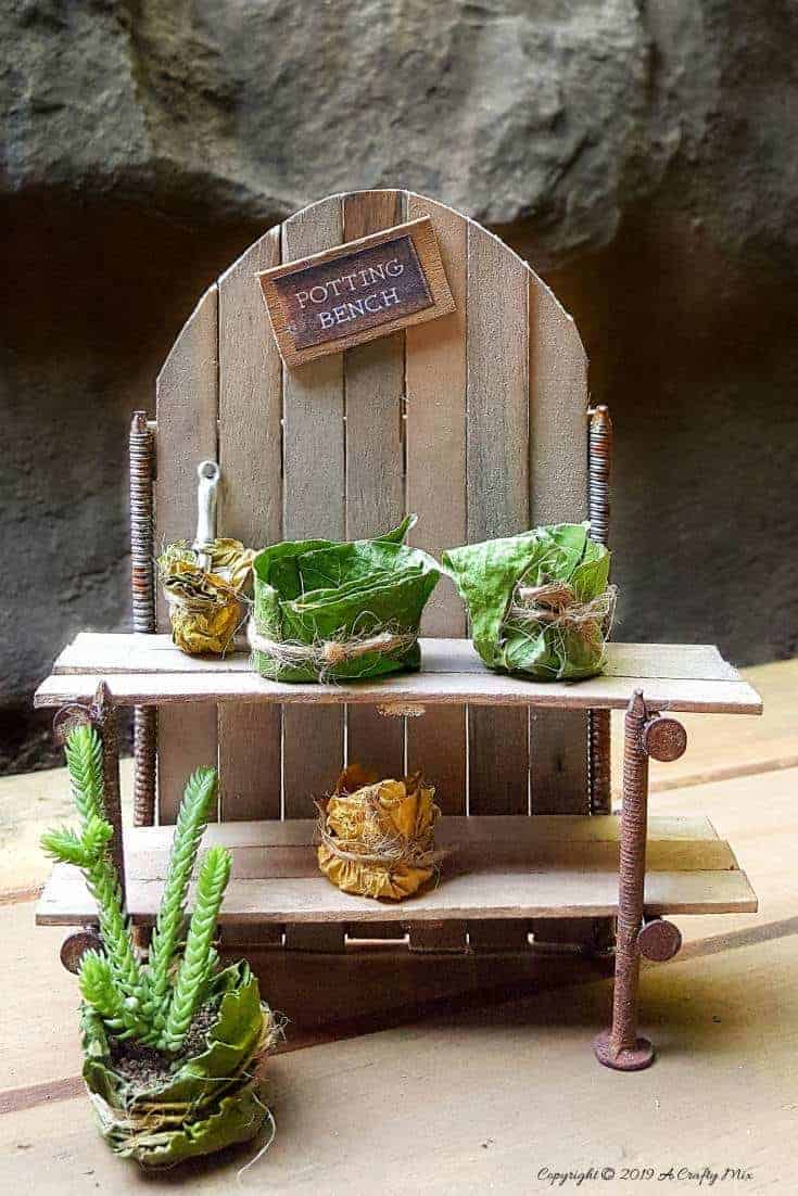 Make this adorable fairy potting bench using rusty nails and stirrer sticks. Quick and easy craft idea for your miniature garden #FairyPottingBench #FairyDIYCrafts #ACraftyMix #FairyGardens #FairyCrafts #WhimsicalFairyCrafts #SimpleFairyCrafts #MiniaturePottingBench #RustyNails