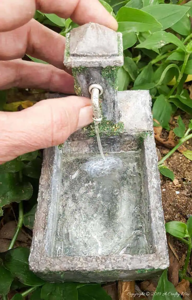DIY Tutorial to make a miniature water feature for your fairy garden complete with "running water" #DIYfairygarden #fairywaterfeature #Fairyfountain #DIYMiniature #FairyGarden #ACraftyMix