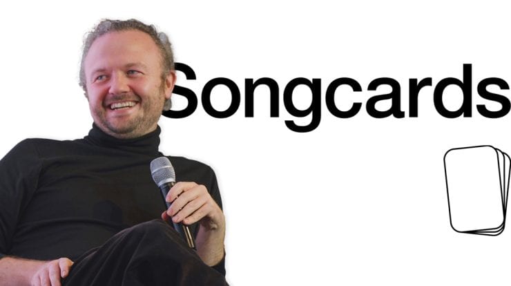 Creative musician holding a microphone at a Songcards event, promoting music streaming and digital music marketing solutions.