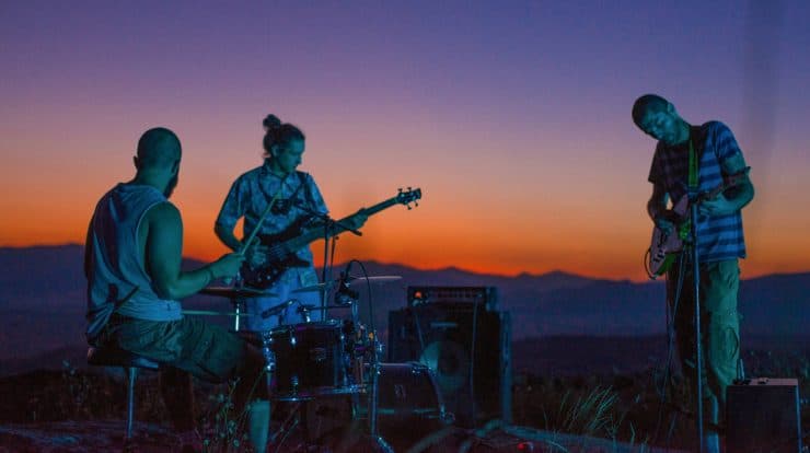 A band performing live at sunset outdoors, showcasing music, musicians, instruments, guitar, bass, drums, sunset scenery, and outdoor concert, perfect for music enthusiasts and live performance lovers.