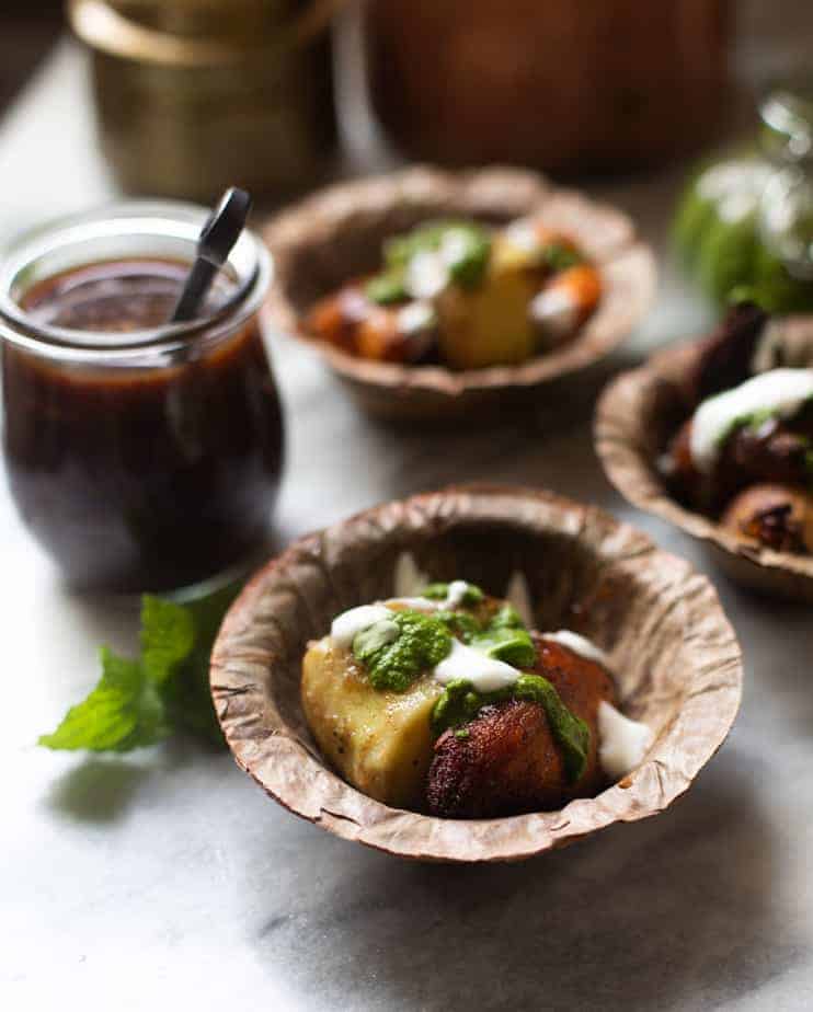 Garnet sweet potatoes with mint chutney served in a leaf bowl