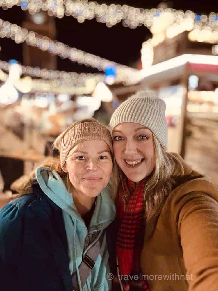 Two friends at a festive market.