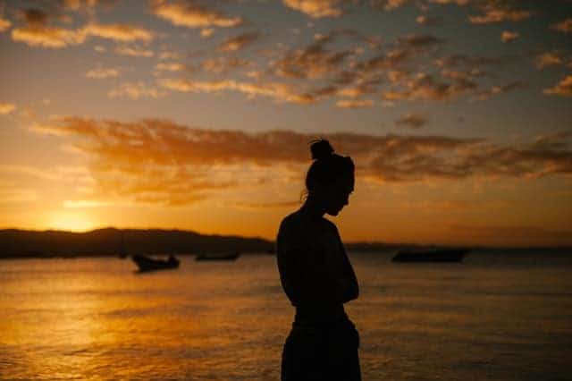 donna triste che cammina sulla spiaggia