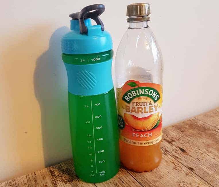 Bottle of peach fruit and barley with a plastic water bottle