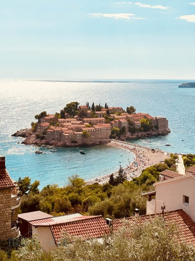 Panoramic view of Sveti Stefan island connected to the mainland by a sandy causeway with turquoise waters — One of the most photographed locations and top things to do in Budva.