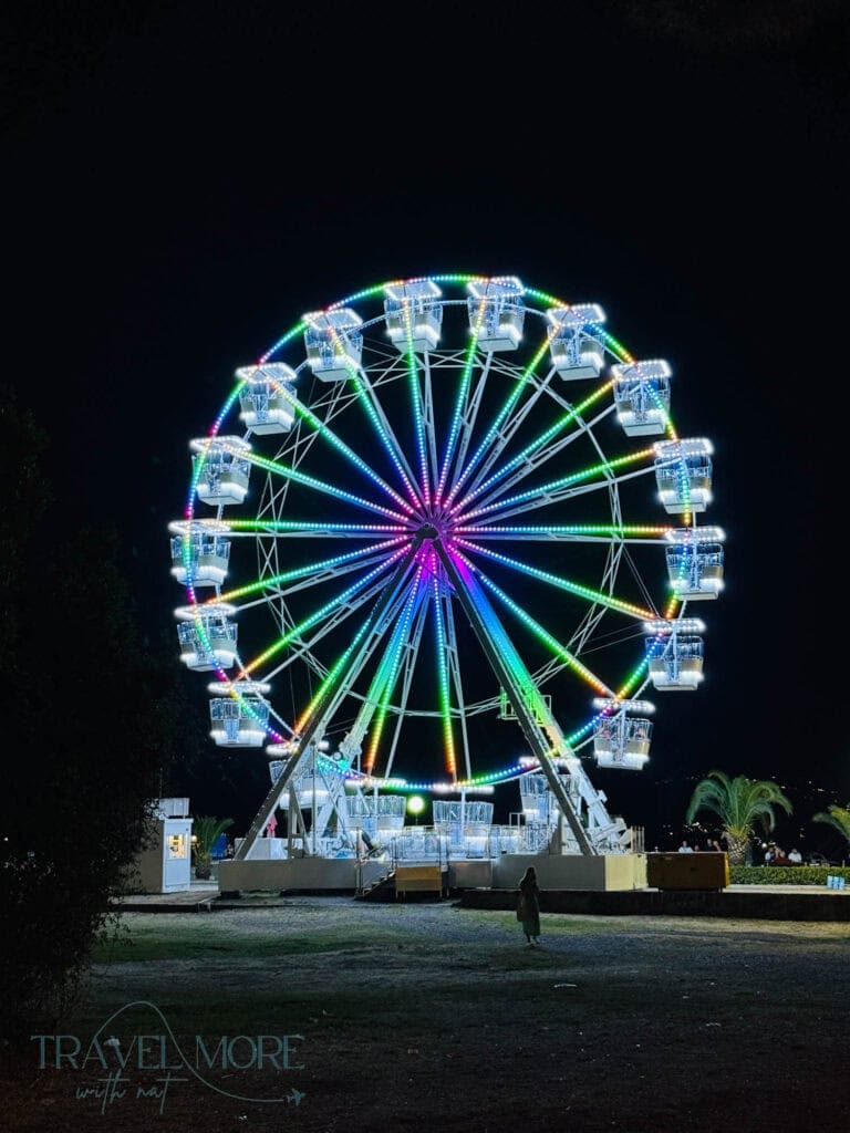 Illuminated Ferris wheel glowing in rainbow colors against the night sky in Budva — A lively evening attraction and a fun pick for things to do in Budva.