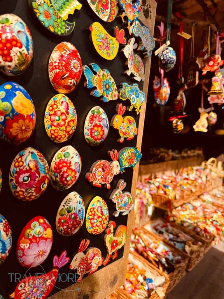 Colorful hand painted Easter ornaments shaped like eggs, birds, and rabbits displayed on a market stall wall. Decorative crafts like these are commonly sold at Vienna Easter markets.