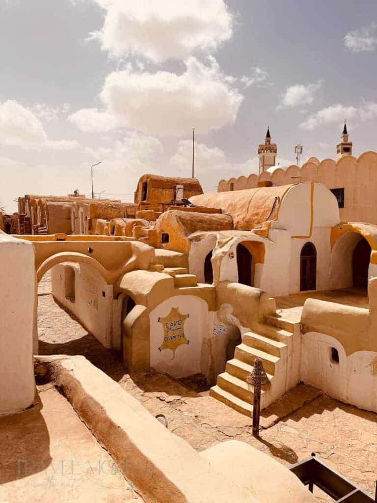 Traditional ochre-coloured village buildings with domed roofs, arches and whitewashed doorways