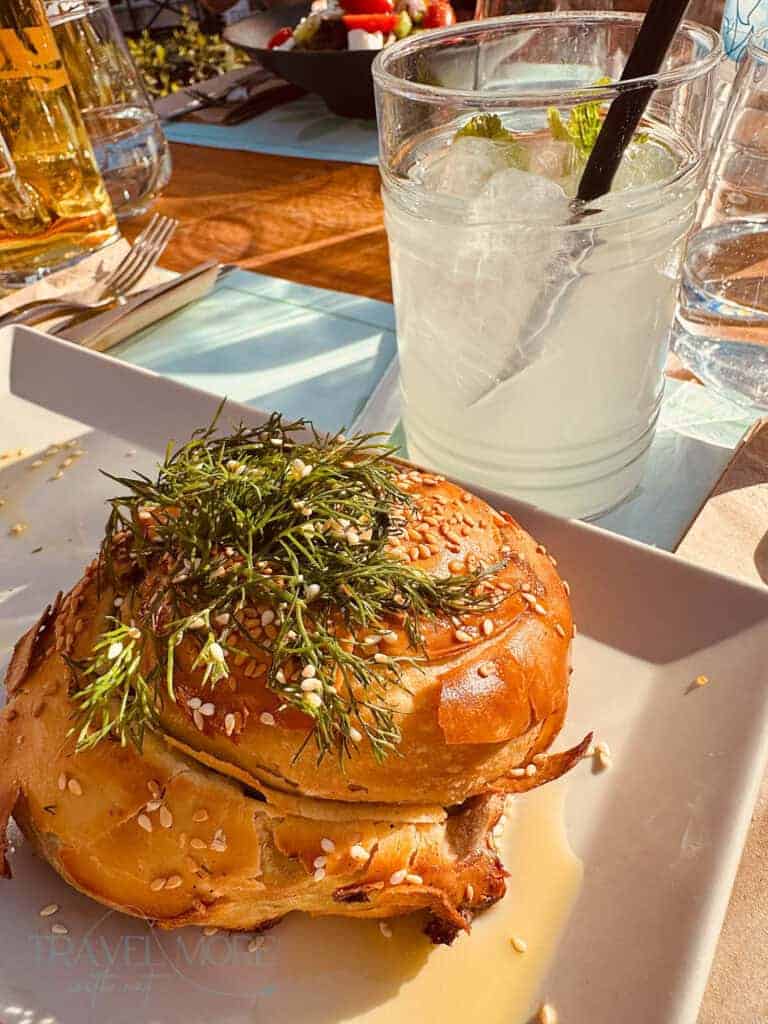 Heatwave travel tips in action, a savoury sesame bun with herbs beside an iced drink