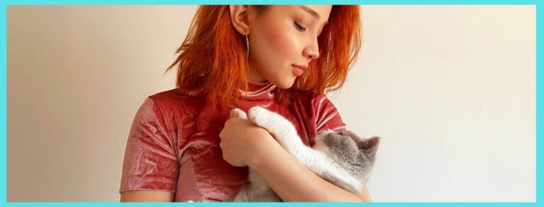 red haired woman and kitten sharing slow blinks one of the way cats show love