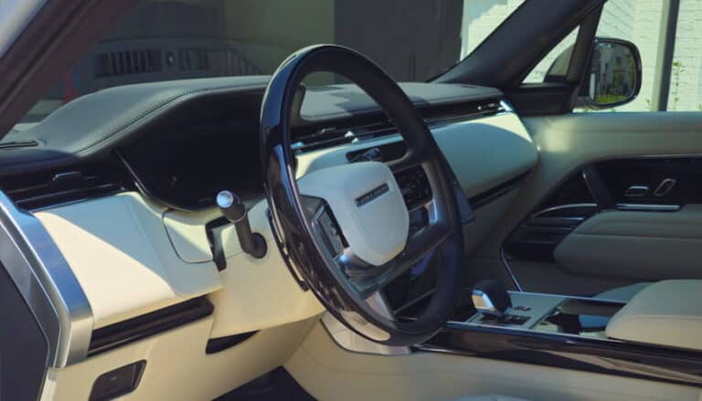 Luxury car interior after professional detailing service in Charlotte NC with spotless dashboard, steering wheel, and premium leather surfaces