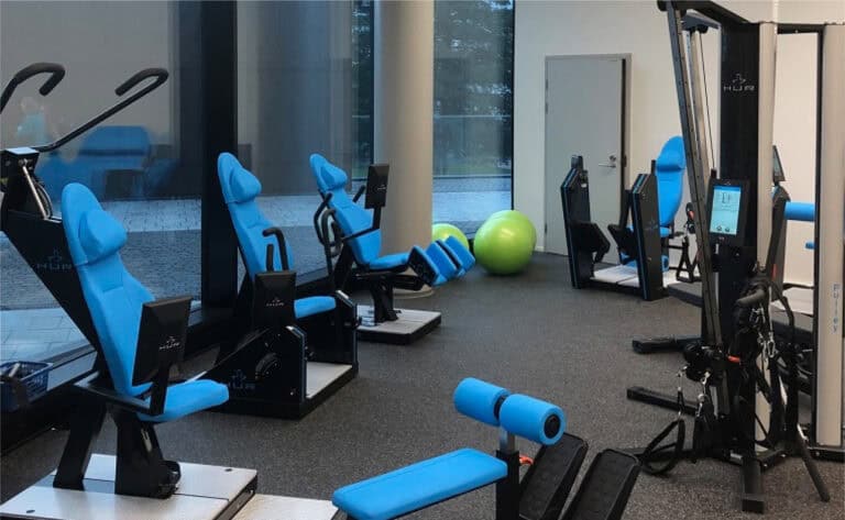 Modern rehabilitation gym with blue exercise machines