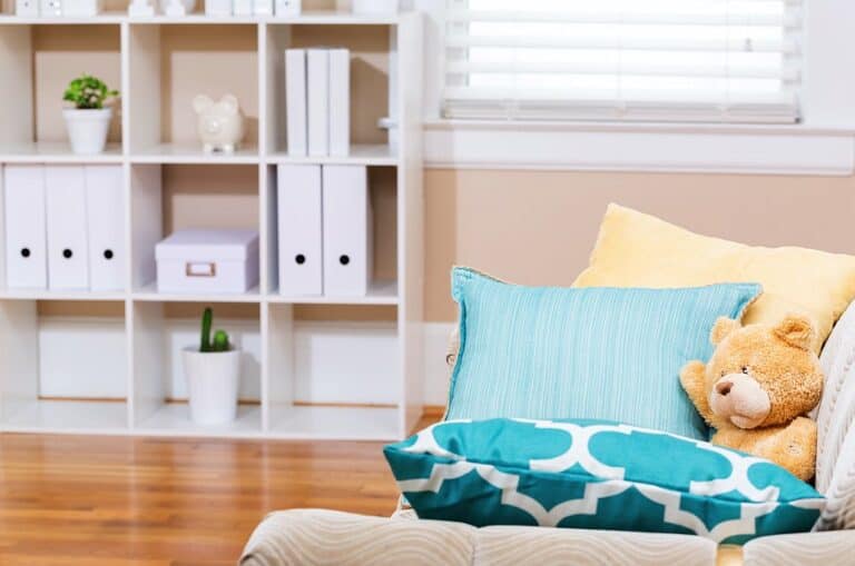 2 plants on wall shelves and a few folders in bright-living-room-interior-with-a-teddy-bear-and-aqua-sofa-pillows