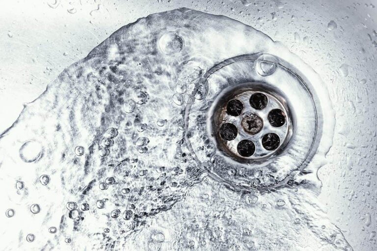 drano being poured down pipe