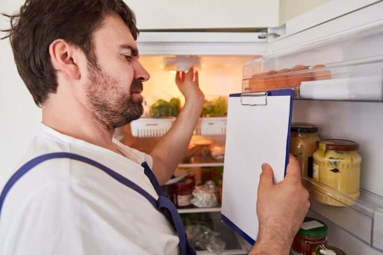 electrician fixing light bulb in fridge