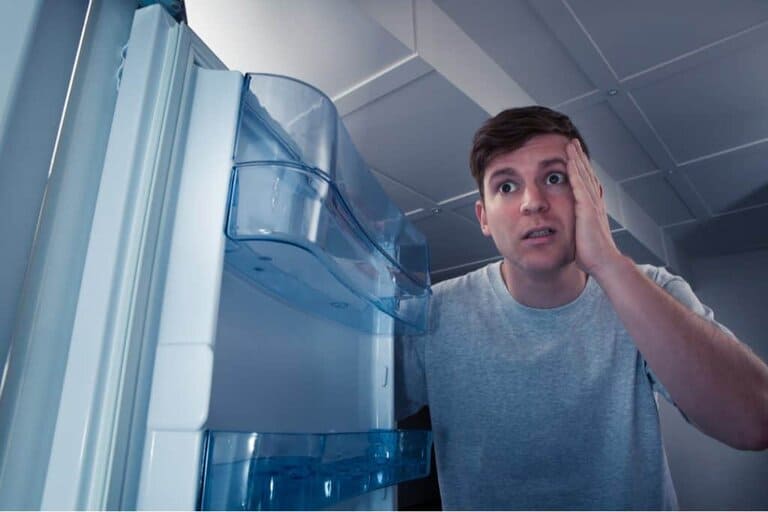 man opening fridge with broken light