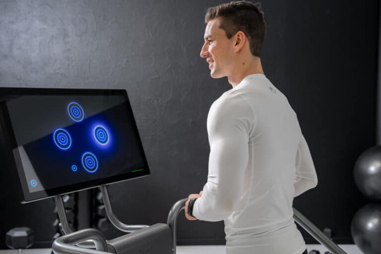 Man engaging with Dividat Neurogym interactive cognitive training screen