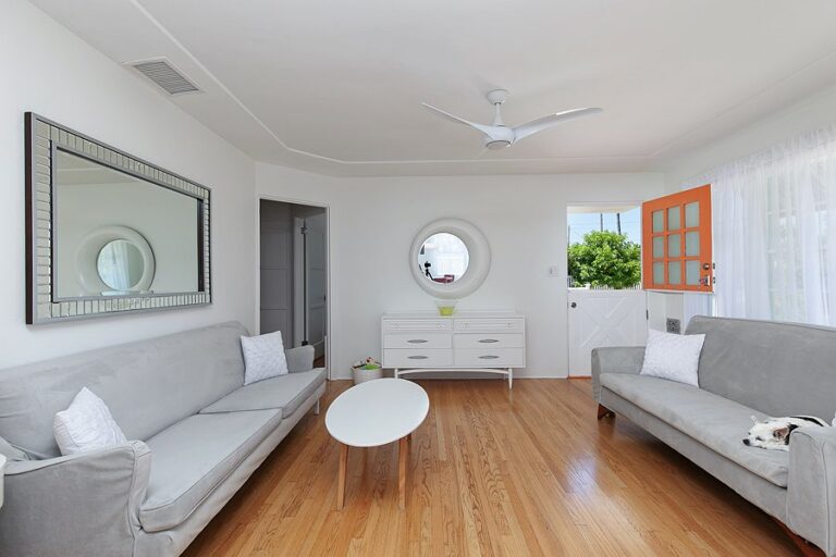 two grey sofas and two mirror on the wall and light painted walls when home staging