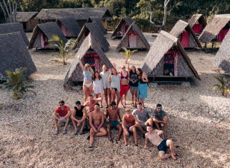 Group picture at campsite with huts in the background